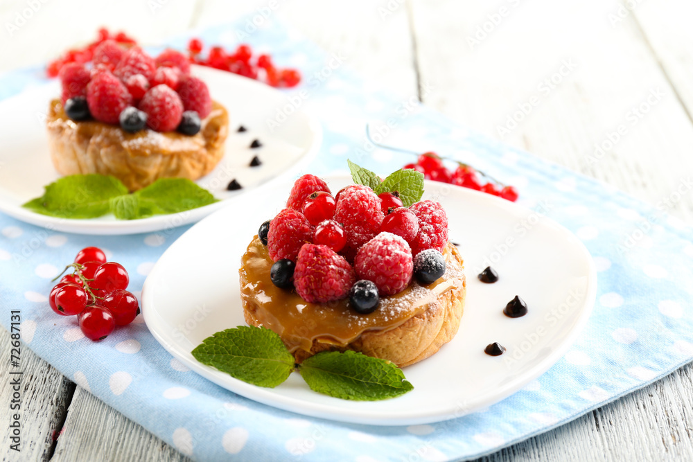 Sweet cakes with berries on table close-up Sweet cakes with berries on table close-up