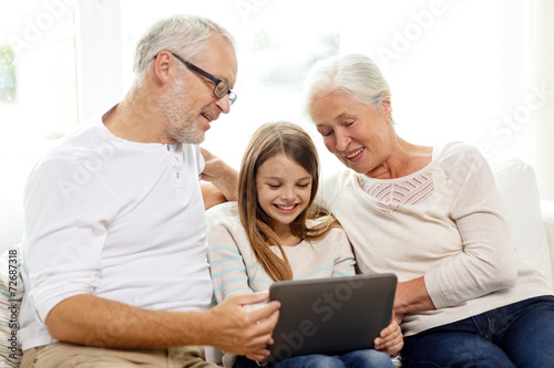 smiling family with tablet pc at home © Syda Productions