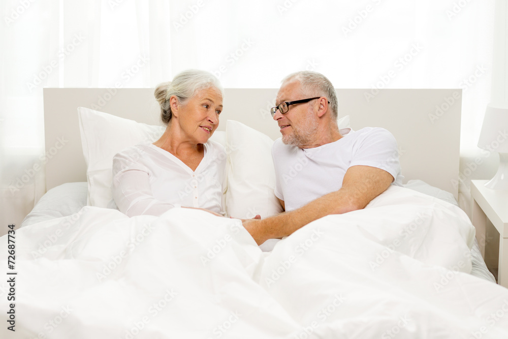 happy senior coupler lying in bad at home happy senior coupler lying in bad at home