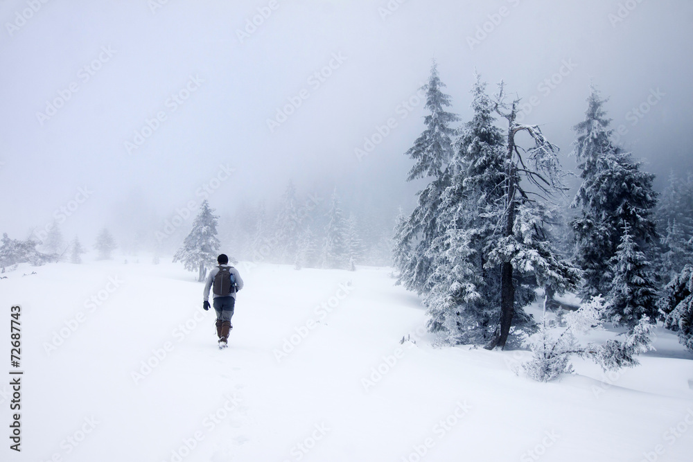 Photographer in foggy winter landscape