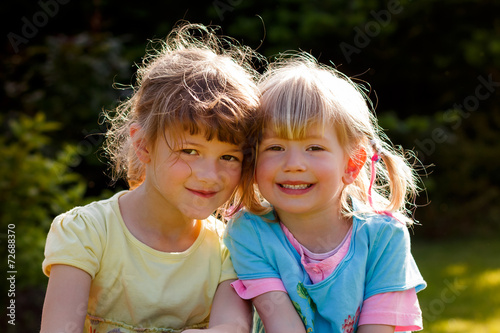 Two young friendly girls in the garden photo