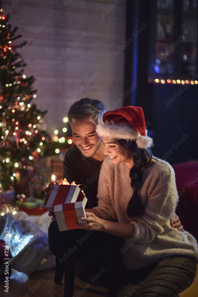 portrait of a young couple in their living room in  christmas ev