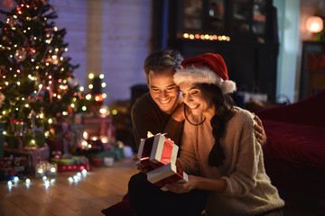 portrait of a young couple in their living room at christmas eve