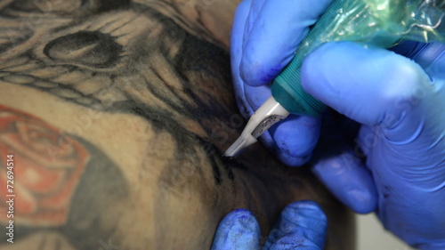 Tattoo artist tattooing a skull