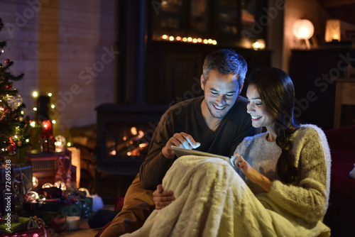 Handsome couple in their decorated living room at christmas eve