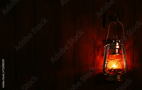 Lantern hanging on hook on wooden wall © Africa Studio