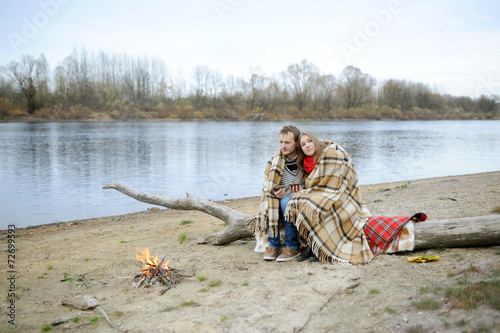 Married couple at the river during the autumn period