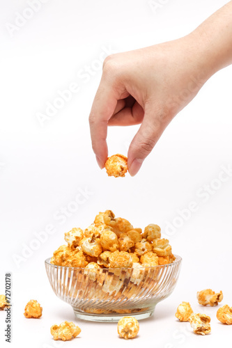 Hand picking caramel popcorn filled in crystal clear bow