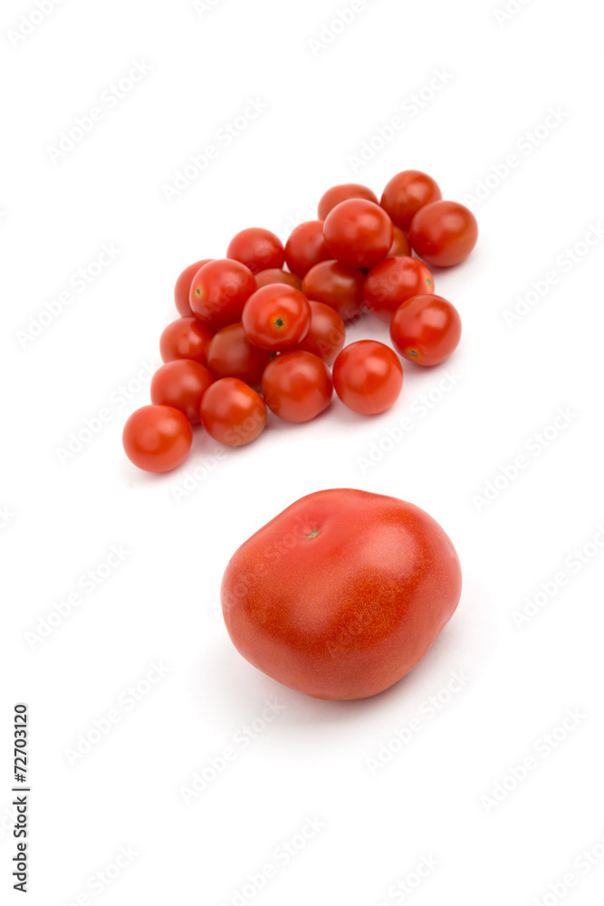 Big tomato on the background of small cherry Big tomato on the background of small cherry