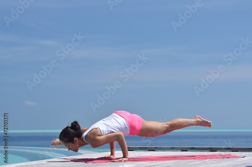 Asian chinese woman practising yoga by the sea