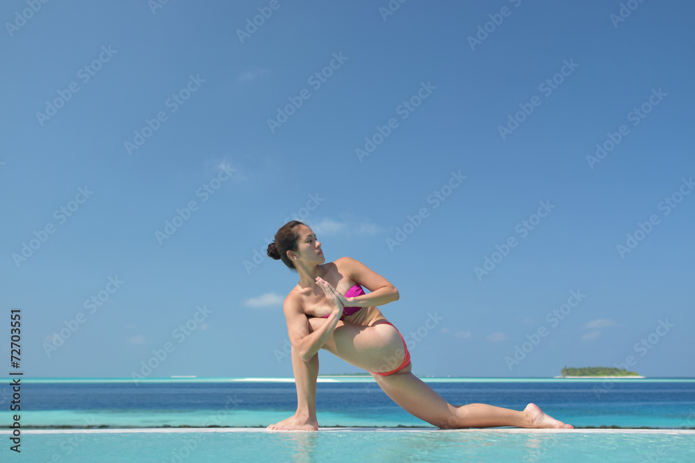 Naklejka premium Asian chinese woman practising yoga by the sea