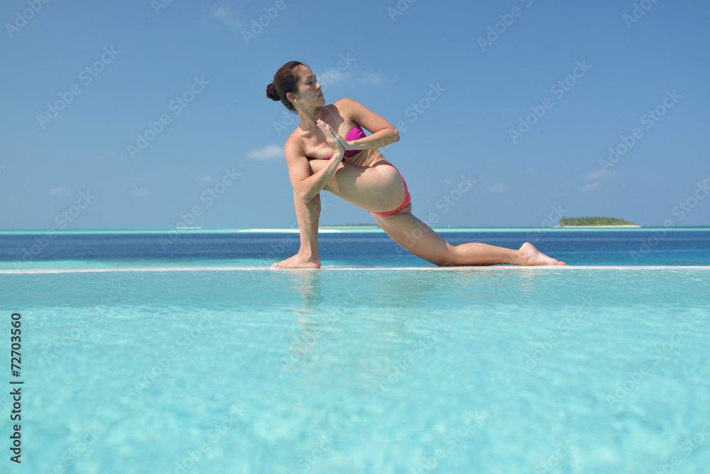 Asian chinese woman practising yoga by the sea