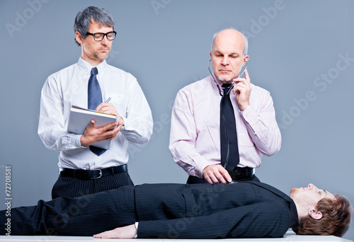 clerks repairing a businessman for fun photo