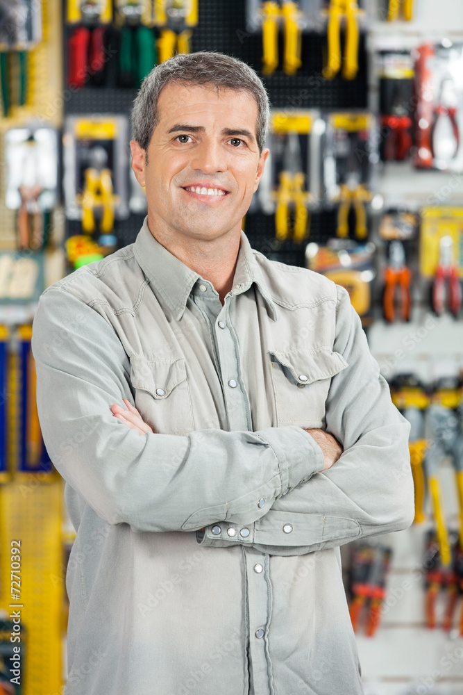 Fototapeta premium Happy Man Standing Arms Crossed In Hardware Store