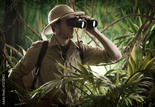 Photo Explorer in the jungle with binoculars
