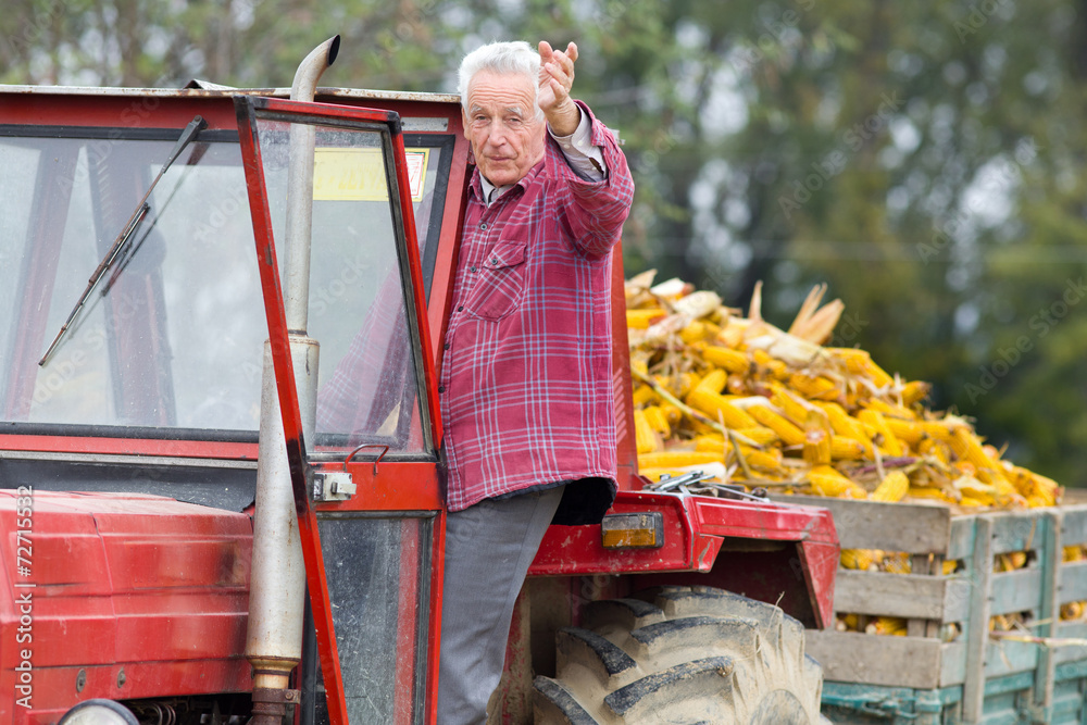 Naklejka premium Senior man in tractor