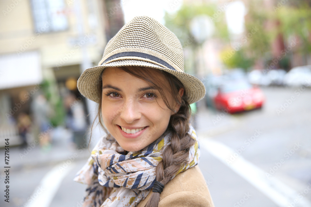 Portrait of smiling woman with scarf and hat in town