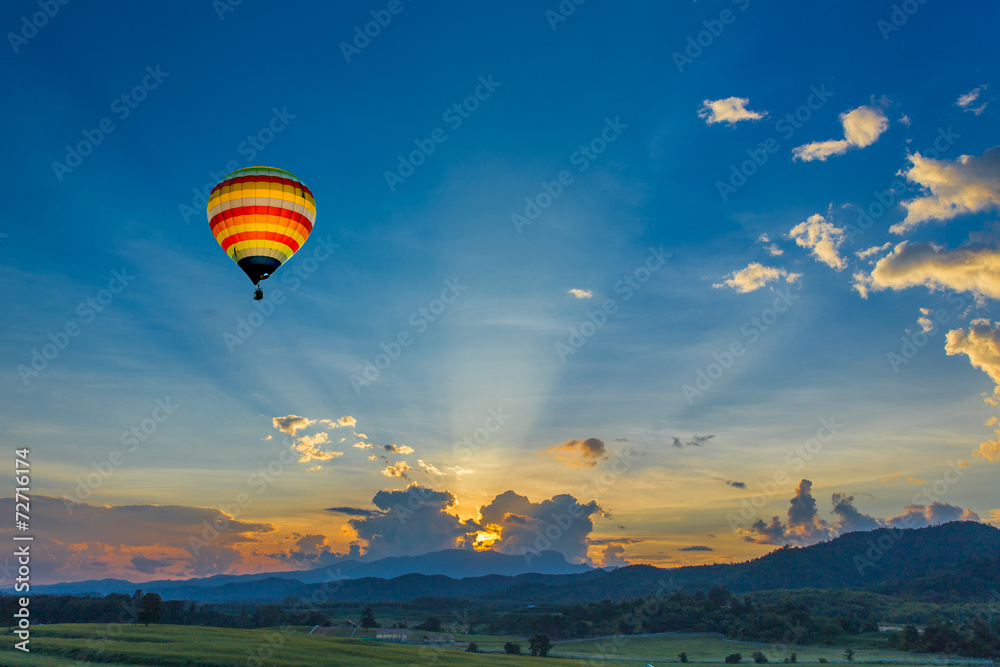 Hot air balloon over the fields at sunset