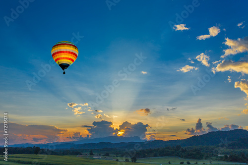 Hot air balloon over the fields at sunset © littlestocker