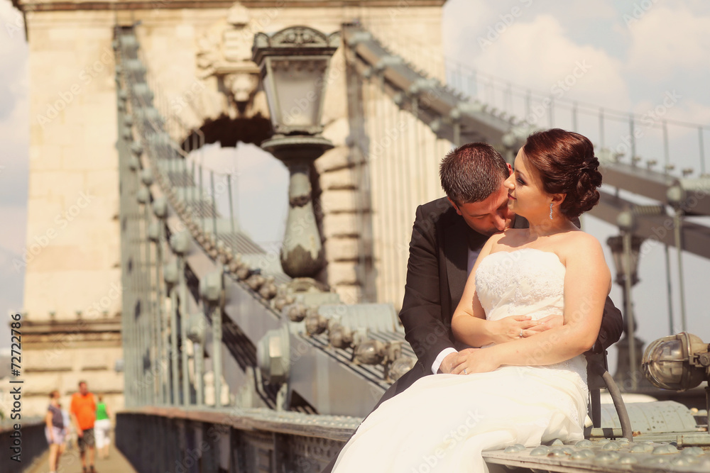 Bride and groom having fun on a bridge in Budapest, Hungary