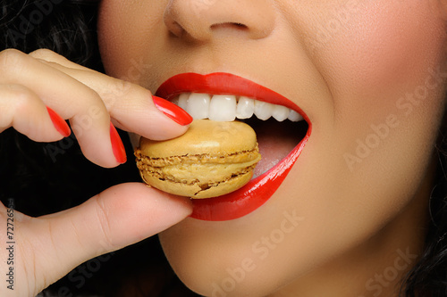 Close up to Macaroon on hand , beautiful caucasian woman eating