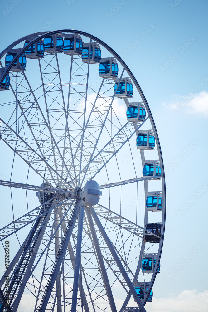 Ferris wheel above blue sky background