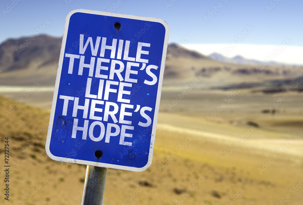 While There's Life There's Hope sign with a desert