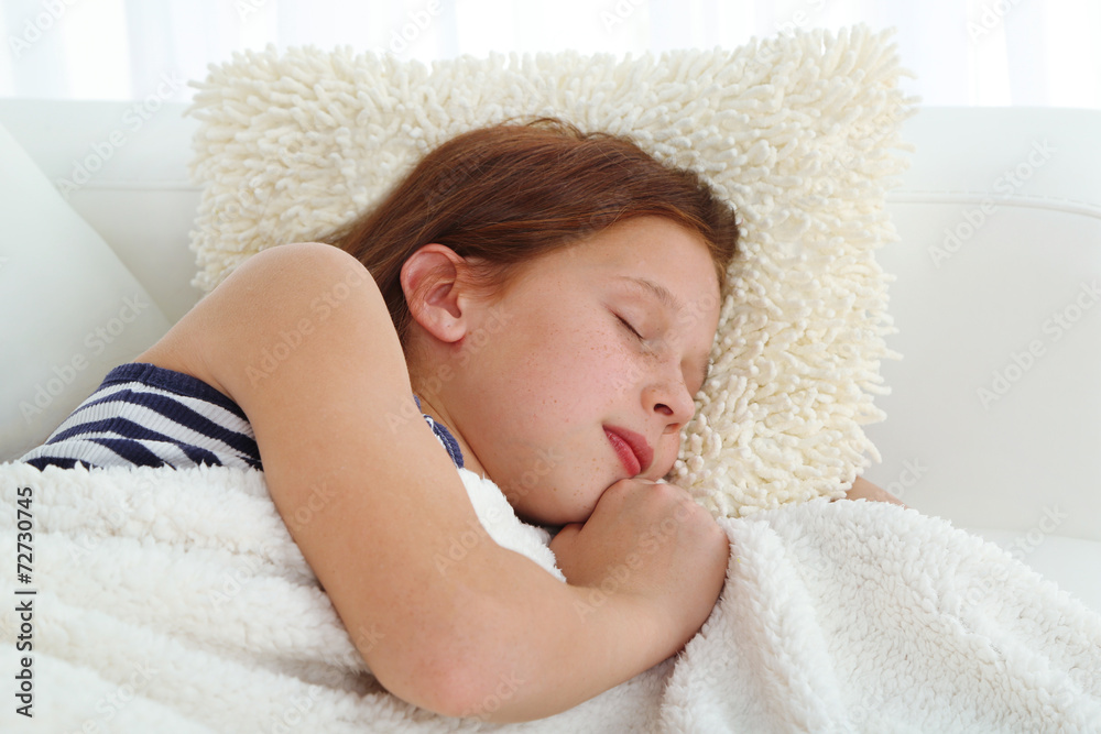 Beautiful little girl slipping on sofa in room Beautiful little girl slipping on sofa in room