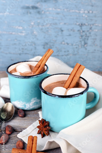 Cups of tasty hot cocoa on table, on light background