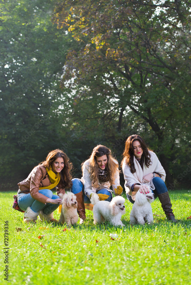 Obraz premium Three young woman with their pet dogs in the park