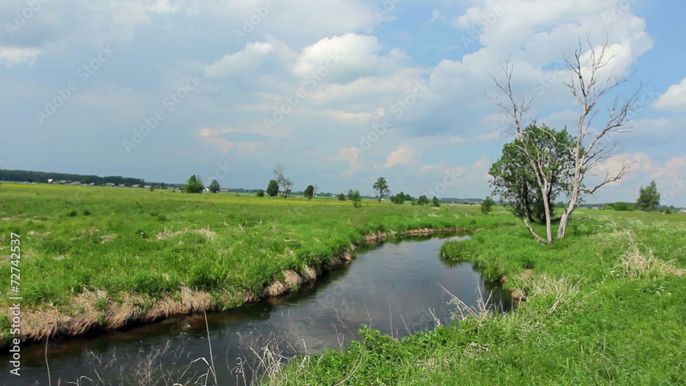 European landscape. Lowland river flowing through the field. European landscape. Lowland river flowing through the field.