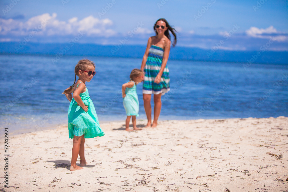 Adorable little girls and young mother on tropical white beach Adorable little girls and young mother on tropical white beach