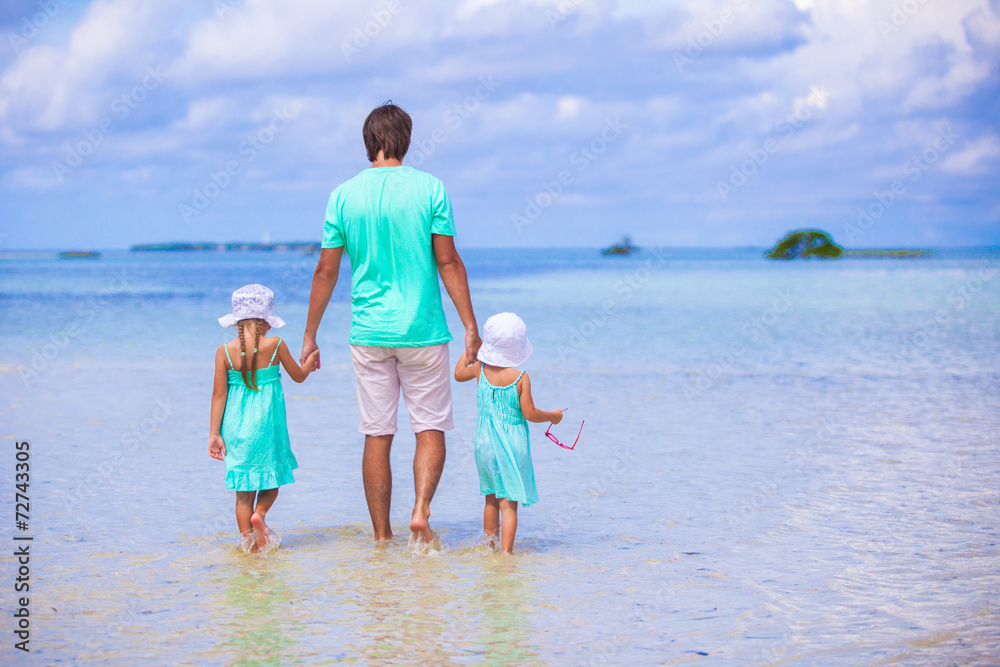 Adorable little girls and young father during beach vacation Adorable little girls and young father during beach vacation