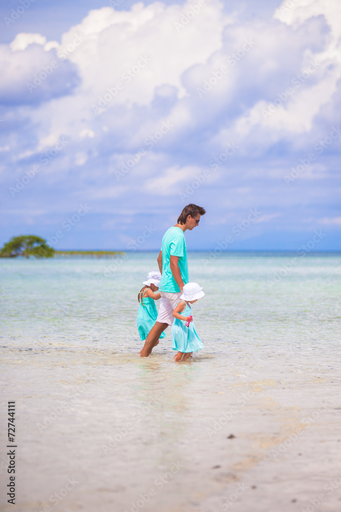 Adorable little girls and young father during beach vacation Adorable little girls and young father during beach vacation