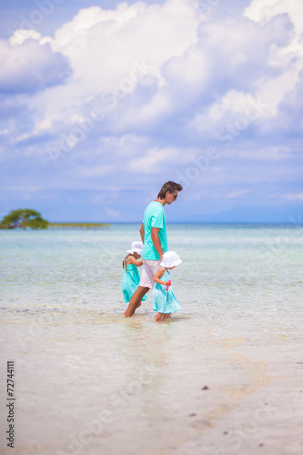 Adorable little girls and young father during beach vacation © travnikovstudio