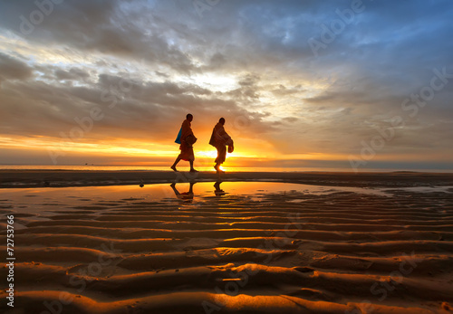 Monks walk on the beach