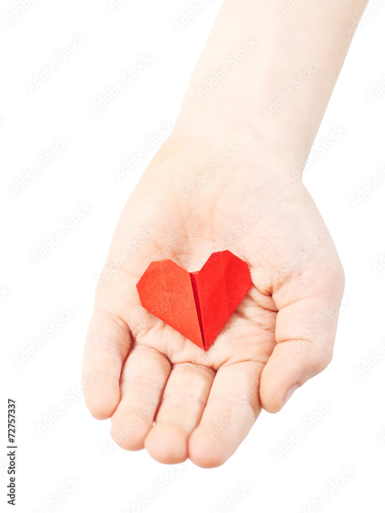 red paper heart in child hand isolated on white background