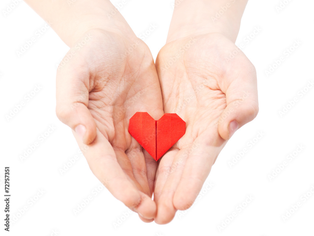 red paper origami heart in childs hand isolated on white background red paper origami heart in childs hand isolated on white background