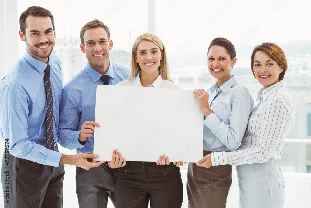 Young business people holding blank board in office Young business people holding blank board in office
