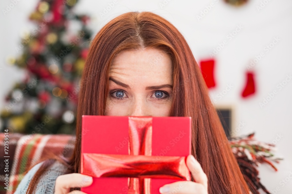 Festive redhead with gift on the couch Festive redhead with gift on the couch