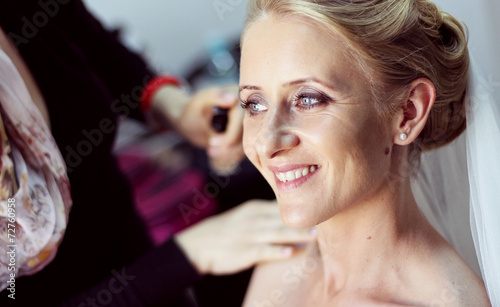 Bride preparing for her wedding day with make up artist