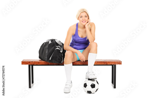 Female soccer player sitting on a bench