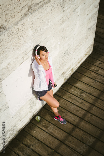 Female athlete wearing headphones and relaxing