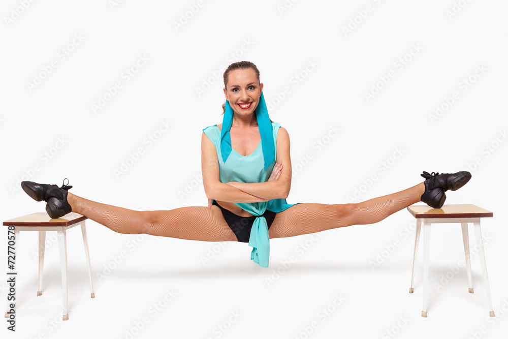 Obraz premium A girl sits in a pose of twine between two stools