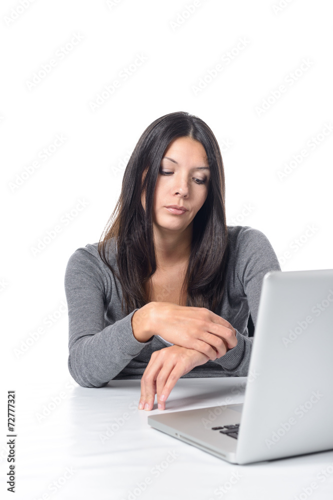 Lustlose Frau im Büro schaut auf ihre Uhr Lustlose Frau im Büro schaut auf ihre Uhr