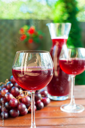 Two glasses of delicious homemade red wine with grape.