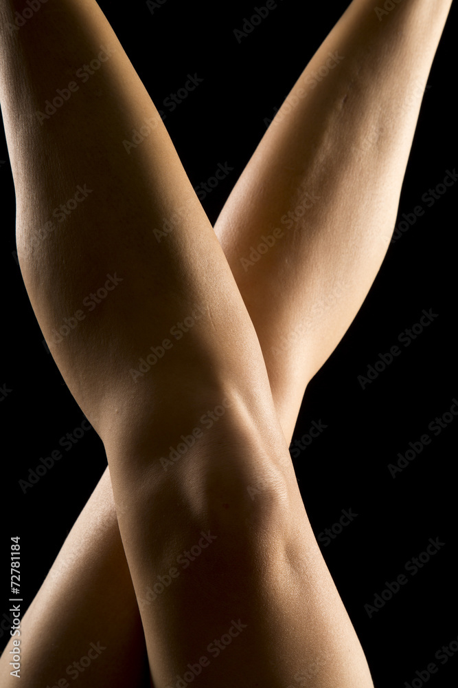Fototapeta premium woman legs on black knees crossed back lit