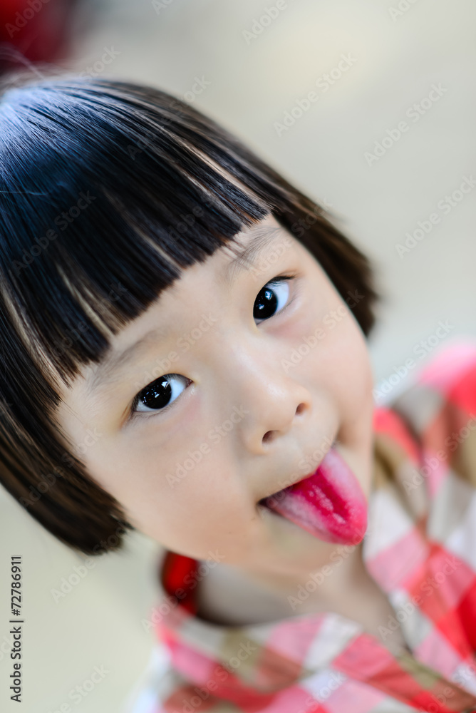 Cute Asian girl showing her red tongue. Stock-Foto | Adobe Stock