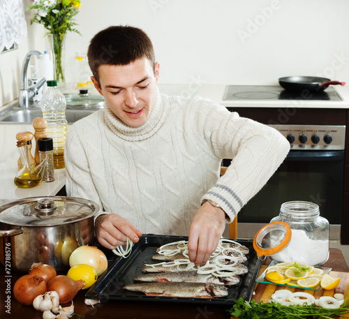  man cooking raw fish and onion photo