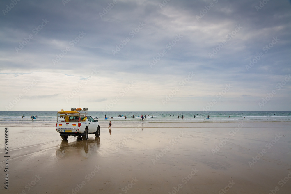 Lifeguard patrolling a beach at Porthtowan in Cornwall, UK